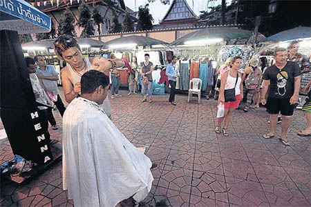 Jun cắt tóc cho người dân địa phương và khách du lịch ở Khao San, Thái Lan.